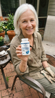 Woman holding Romira Liposomal Glutathione on her patio